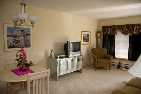 a living room with a tv and a table and a chair